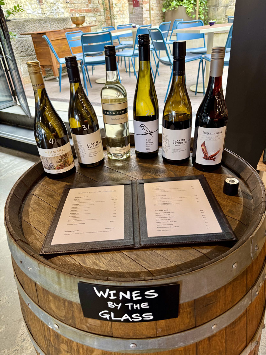 Wine bottles and glasses set on a barrel